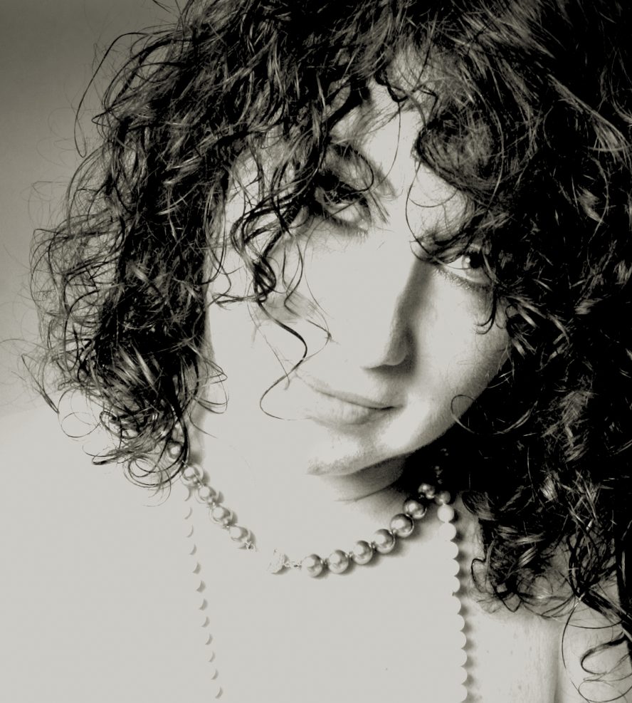 black and white photo of a white woman with curly hair and necklaces