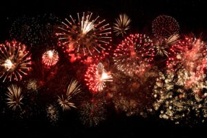 dark background with fireworks exploding in reds and yellows