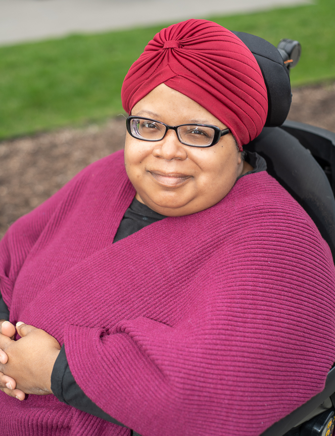 Shameka Andrews sitting in her wheelchair, wearing a pink shawl.